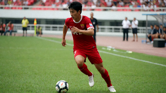 足球比赛中球员带球推进的赛场画面